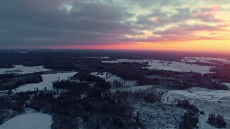 drone volando sobre un paisaje nevado con puesta de sol en el fondo