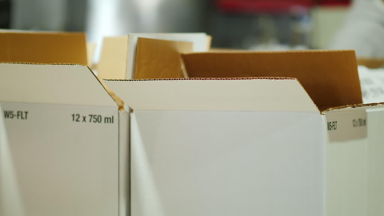 작업자는 와인 병을 상자에 넣습니다.