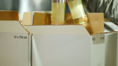 los trabajadores ponen botellas de vino en cajas