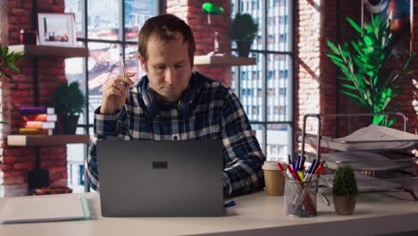 mockup tablet next to worker in home office wearing headphones editing documents