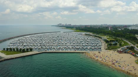 fixed aerial view of 31st street harbor and 31st street beach on crowded summer day