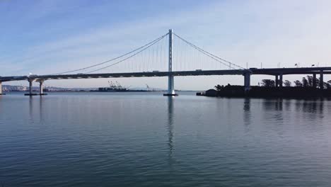 Low-Angle-Zoom-In-Drone-Shot-of-the-San-Francisco-Bay-Bridge-near-Treasure-Island