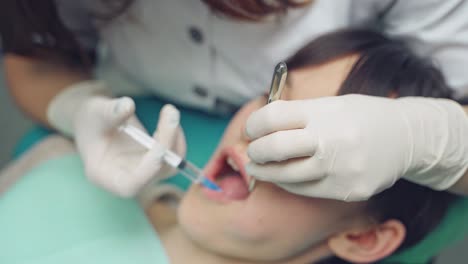 dentist is treating a patient in a modern dental office.