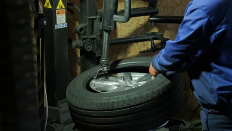 change a tyre, car mechanic is changing a tyre in a garage