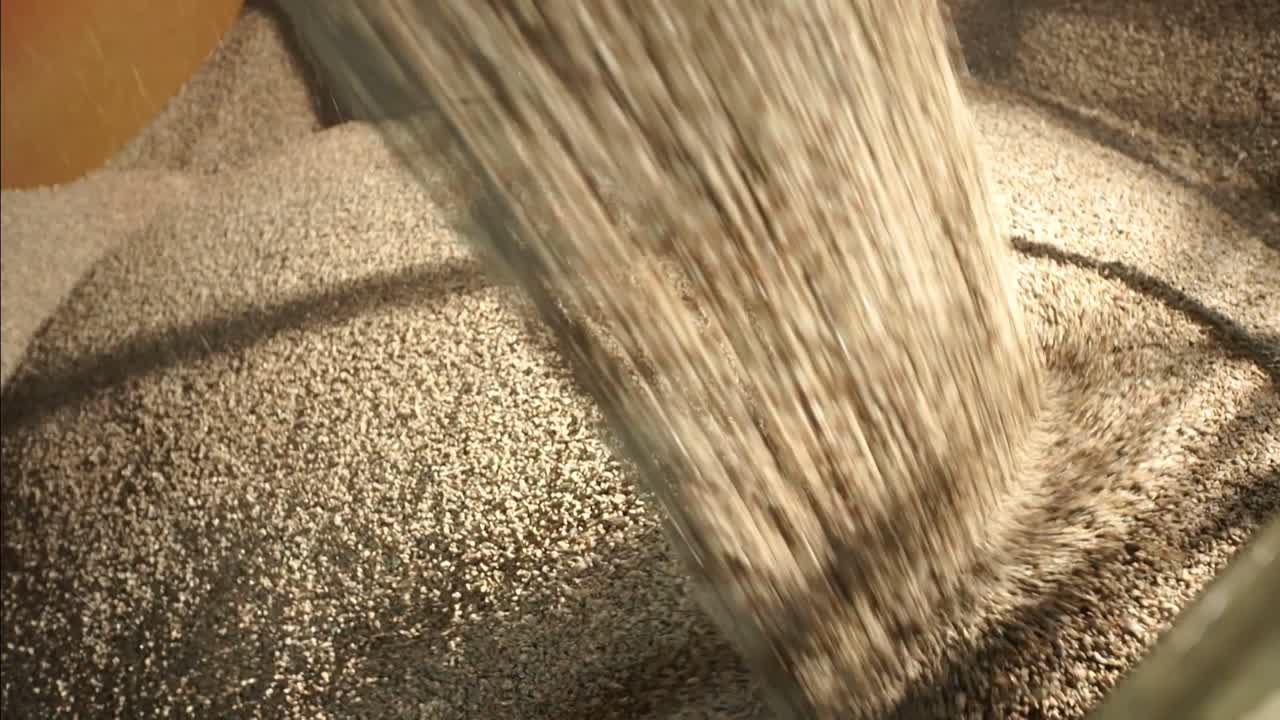 Clinkers Pouring Into Large Container At Cement Production Plant. close up