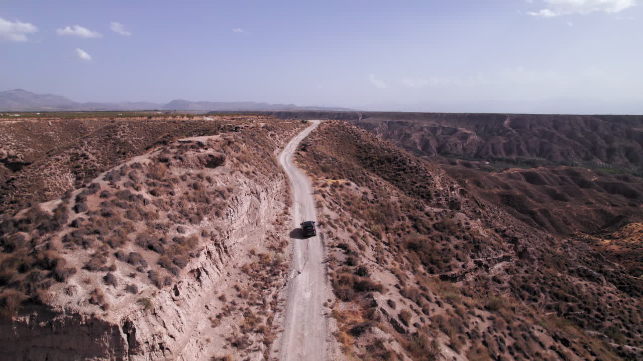 Car driving up a ridge on the Gorafe desert, Spain