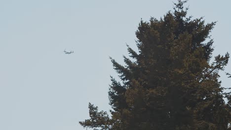 two v-22 osprey military tilt rotor planes passing by in the distance