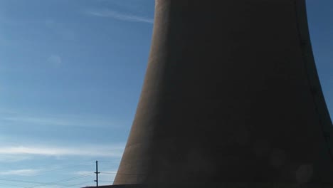 the camera pans from the base to the top of a nuclear power plant