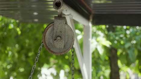 una polea de cadena oxidada en un pozo cubierto. disparo de primer plano