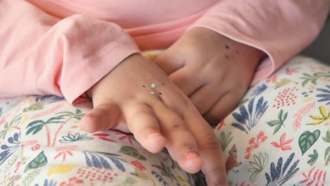 close-up of a toddler's hand with glitter