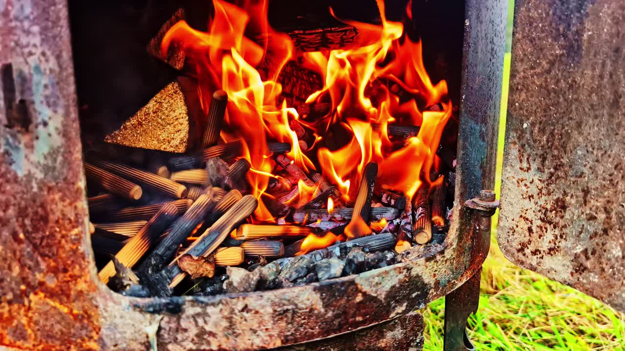 Glowing hot coals and embers in fireplace or grill, strong red-orange heat and fire texture, burning thin pieces of wood
