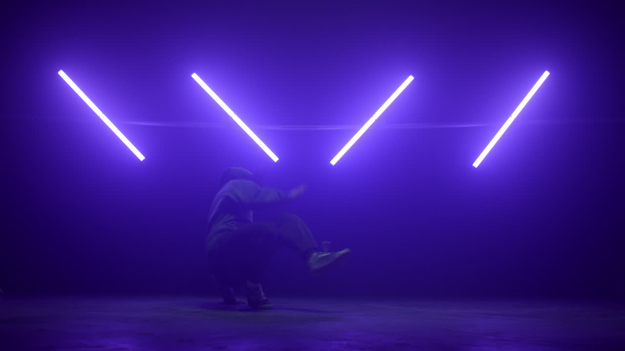 un tipo haciendo trucos de breakdance en la pista de baile de un club nocturno.