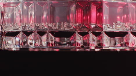 close-up of a faceted glass filled with red liquid