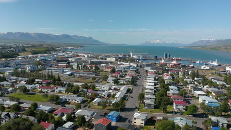 High-angle-view-of-Reykjavik-city-centre-downtown-with-characteristic-colored-rooftops.-Top-panoramic-view-of-Iceland-capital-city-coastline-with-beautiful-snowy-mountains-in-background