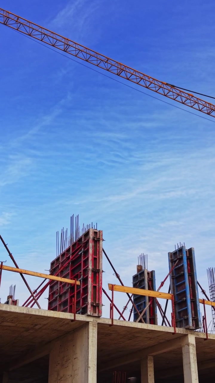 Construction site with cranes and rising structures under blue sky