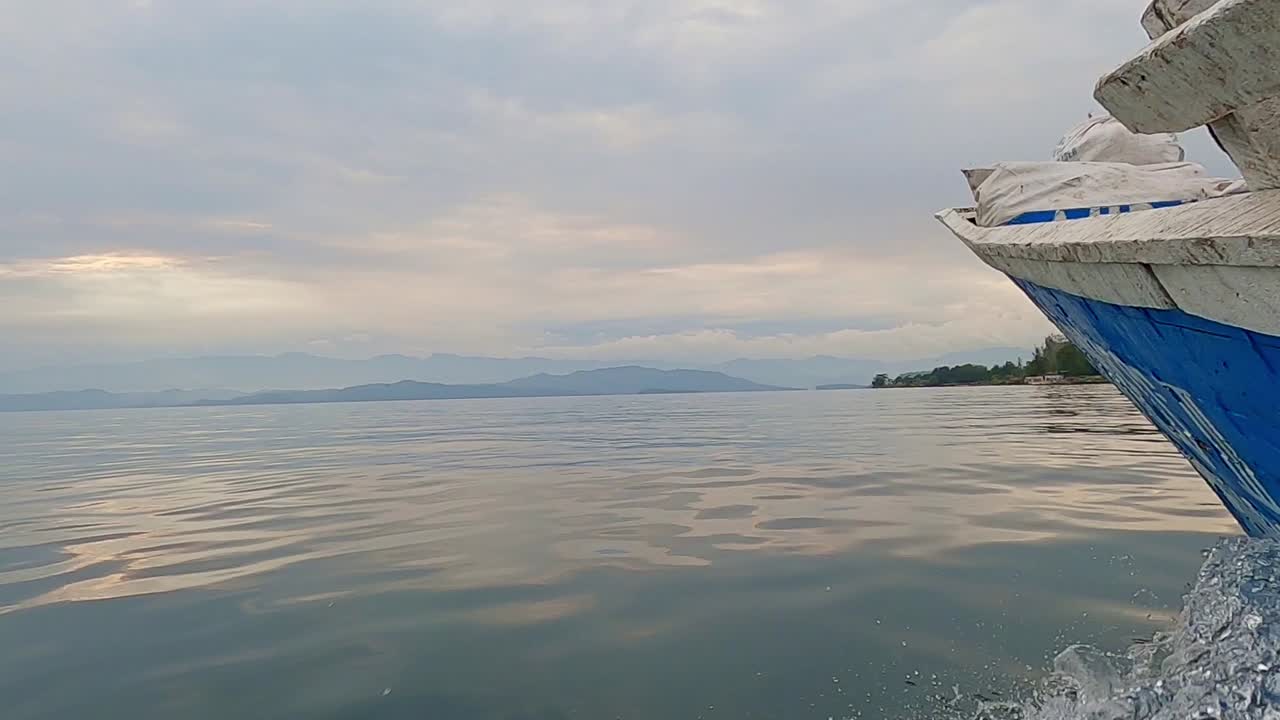 멀리 산을 향해 바다에서 순항 보트의 낮은 각도 보기