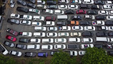 aerial: drone panning left to right high above a parking zone full by cars, people stuck in the queue wait for ferry from the koh chang island to mainland of trat, thailand, asia