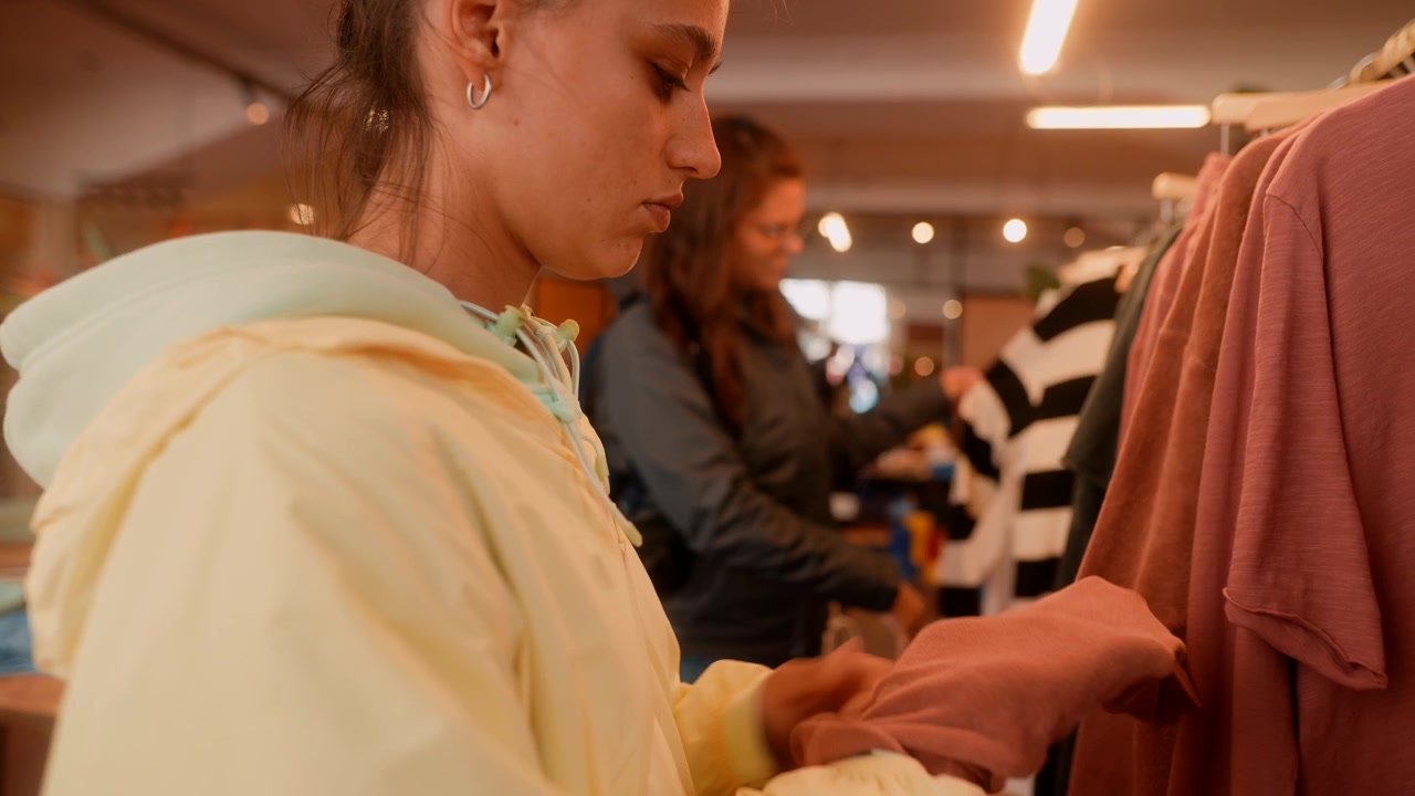 Wanita Muda Melihat-lihat dan Memeriksa Pakaian di Toko Ritel