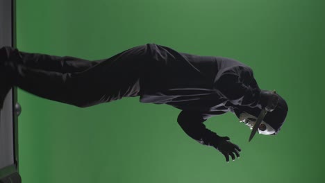 man in a mask with a knife on a green screen