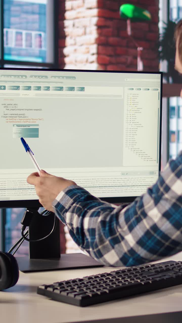 Vertical video Programmer at desk typing code into computer, developing software programs