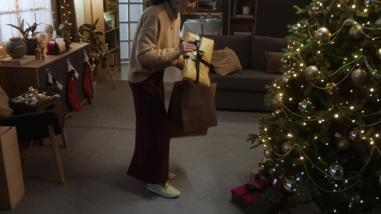 Senior Woman Putting Presents Under Christmas Tree