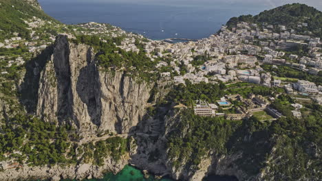 Capri-Italia-V5-Drone-Cinematográfico-Aéreo-Sobrevolando-El-Mar-Capturando-Escarpados-Acantilados-Costeros,-El-Paisaje-Azul-De-La-Ciudad-Isleña-Y-El-Encantador-Vecindario-Junto-Al-Acantilado-En-Verano---Filmado-Con-Mavic-3-Cine---Mayo-De-2023