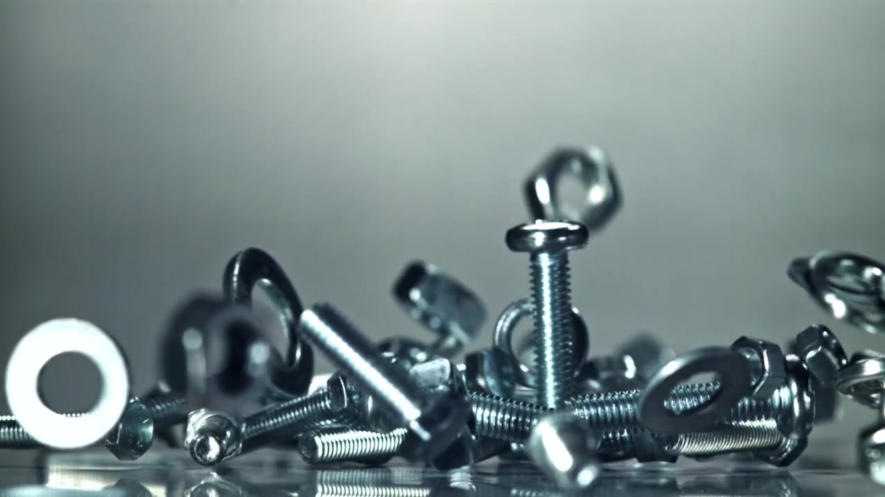 Bulloni, dadi e rondelle metallici che cadono in super slow motion