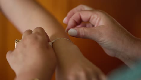 hands delicately fastening a bracelet on a wrist