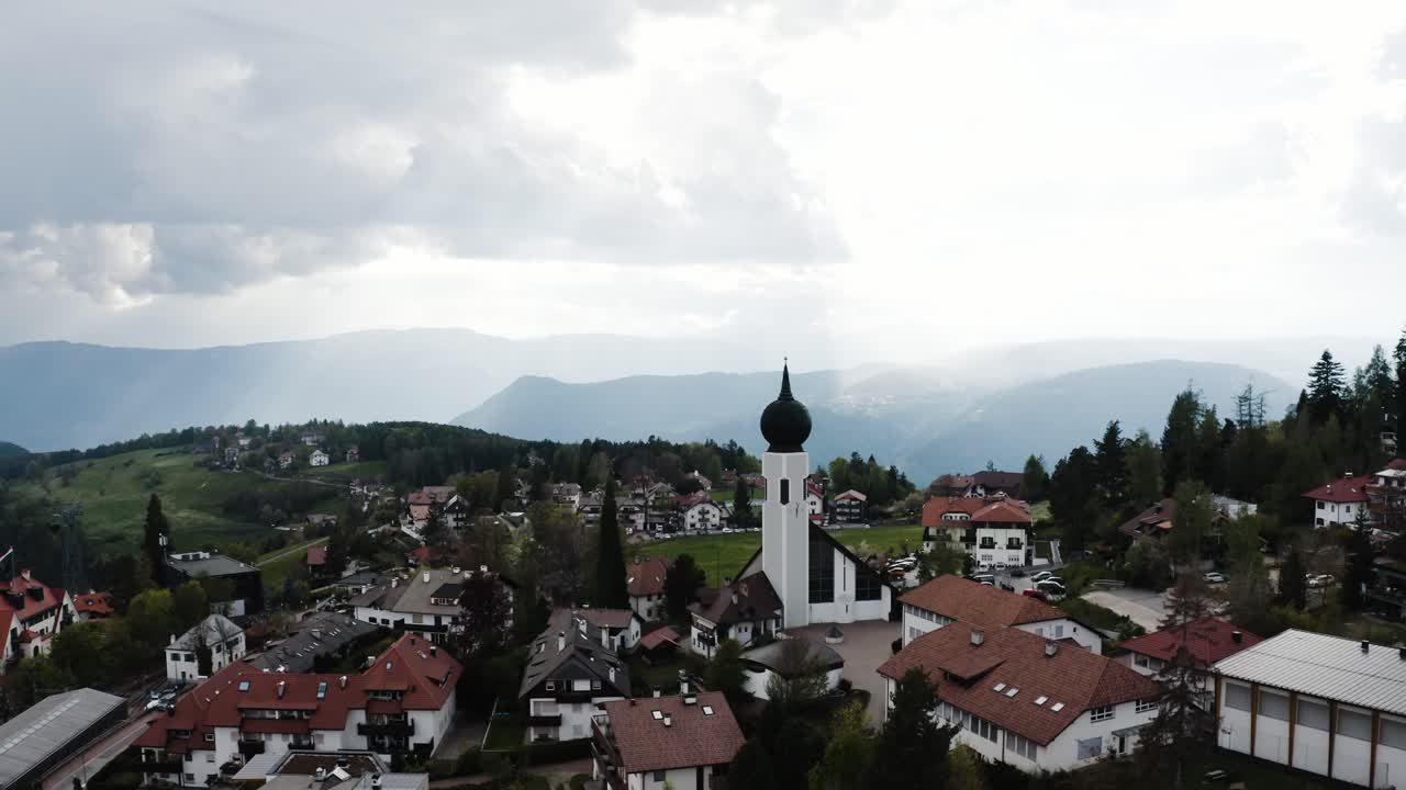 estableciendo una vista aérea de oberbozen, italia en un día nublado