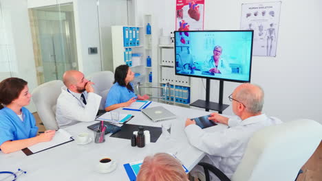 team of medical staff during video conference with doctor in hospital