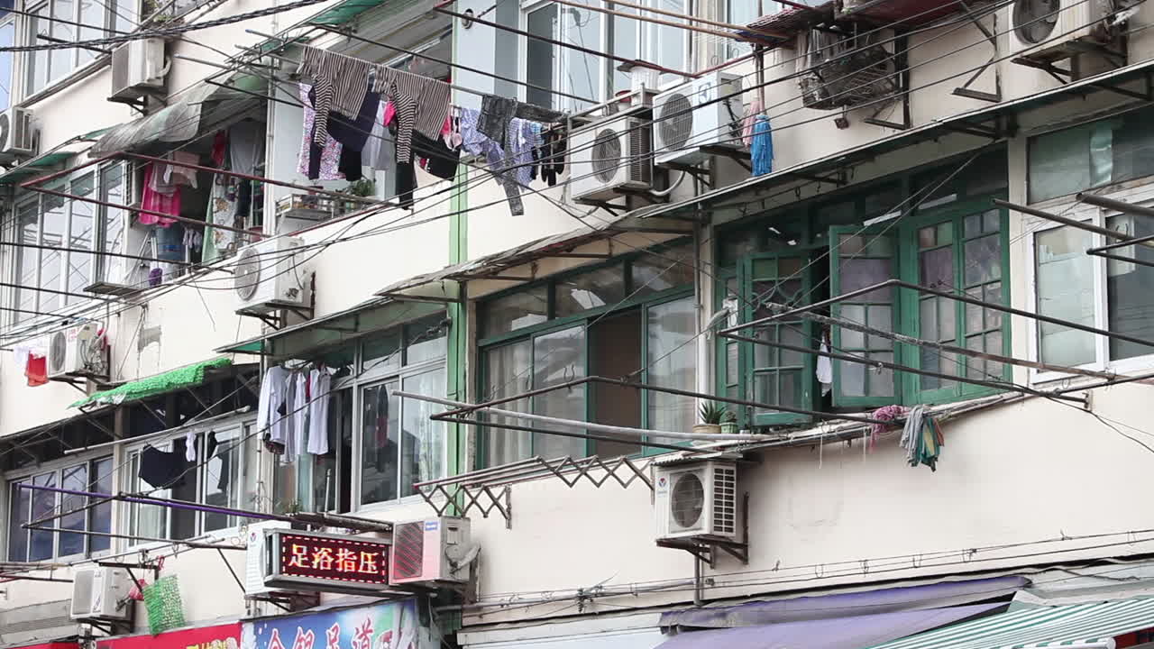 la ropa cuelga para secarse en los postes tradicionales de los edificios de apartamentos en shanghái, china