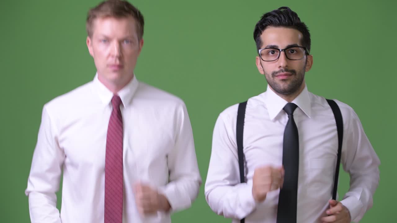 초록색 배경에서 함께 일하는 두 명의 젊은 다민족 사업가