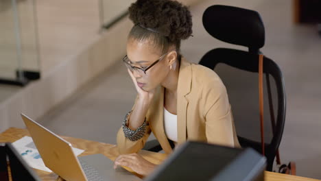 African-American-business-businesswoman-focuses-on-her-laptop-in-an-office