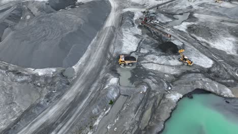 Aerial-top-down-shot-of-working-excavator-and-truck-dump-trailer-on-mine-site-in-america