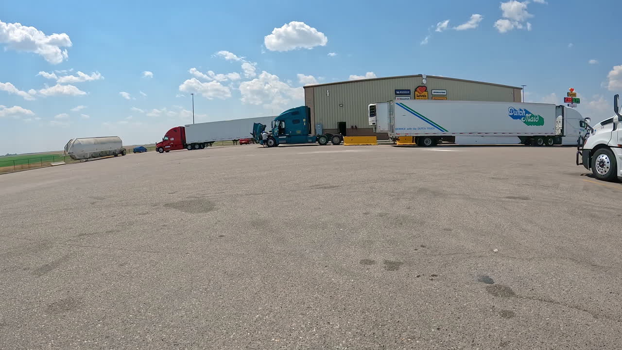 POV - Driving though the truck parking lot towards the tire repair shop for Love's Travel Stop; concepts of logistics, road trip and highway transportation