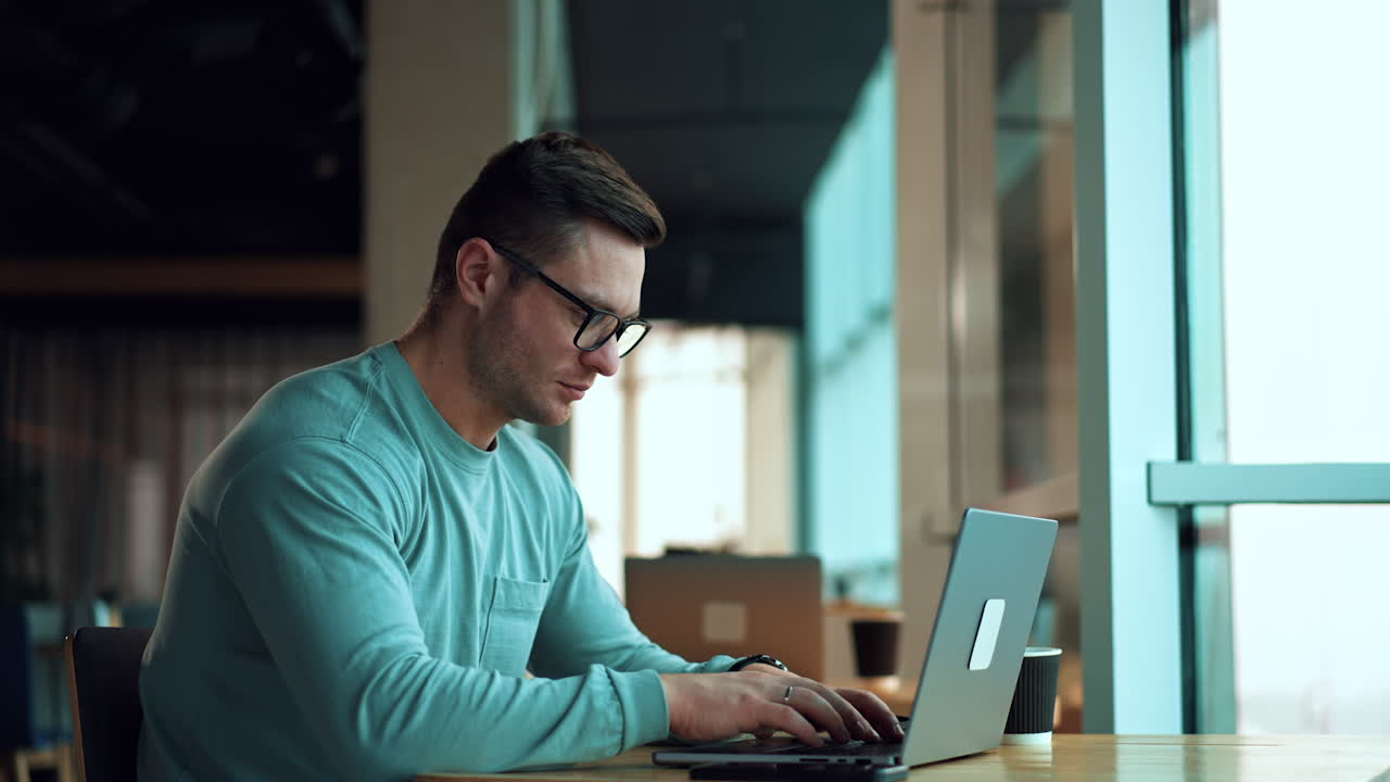 hombre trabajando en una computadora portátil en un café