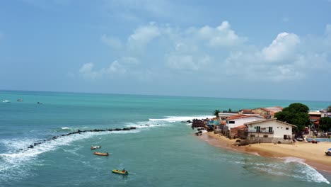 Right-trucking-aerial-drone-shot-of-the-Cacimba-beach-in-the-famous-beach-town-of-Baia-Formosa-in-Rio-Grande-do-Norte,-Brazil-with-fishing-boats,-houses-along-the-coast-and-small-waves