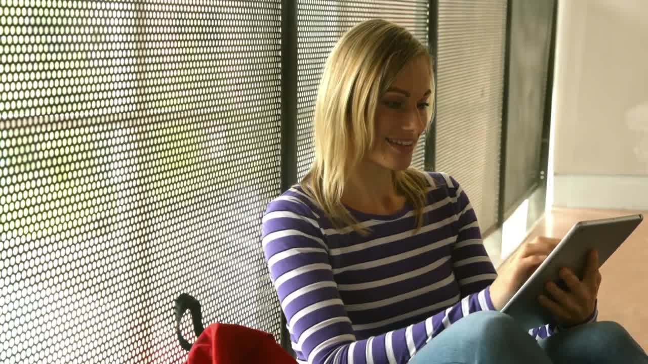 대학에서 태블릿을 사용하는 미소 짓는 학생