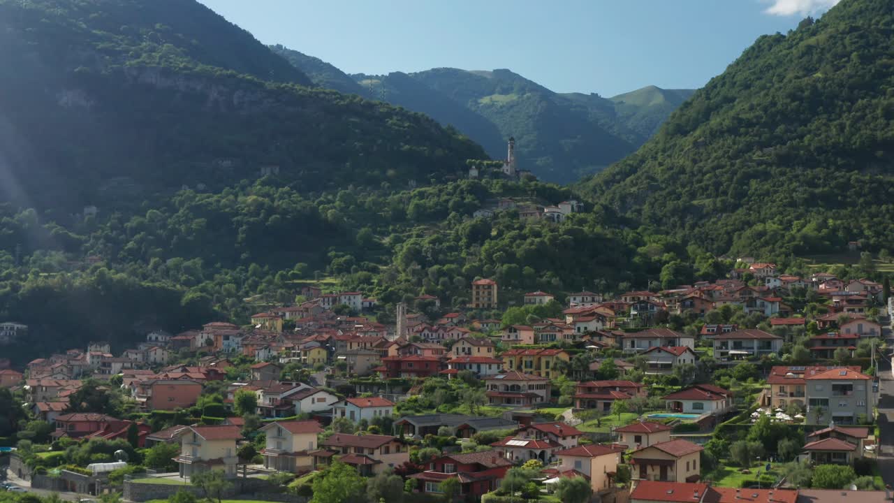 un día soleado sobre el tranquilo pueblo de ossuccio en el lago como, con exuberantes colinas en el fondo.