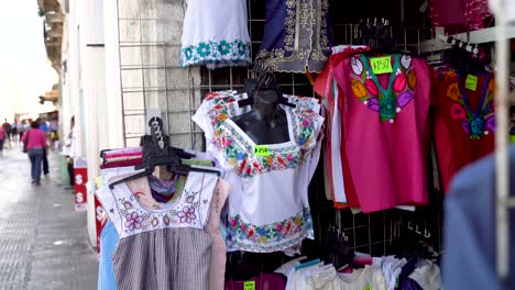 camera pushes in and rotates showing mexican blouses for women in a store in merida, mexico