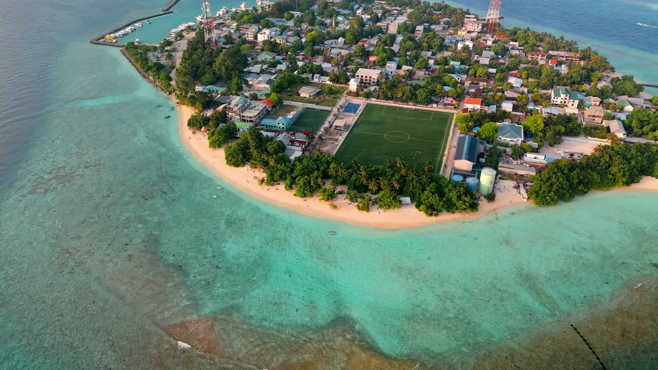 A breathtaking aerial drone view captures Rasdhoo Island bathed in the warm glow of sunset in the Maldives.