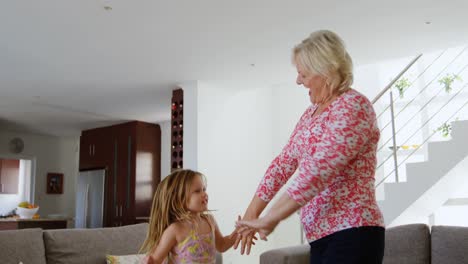 grandmother and granddaughter dancing in living room 4k