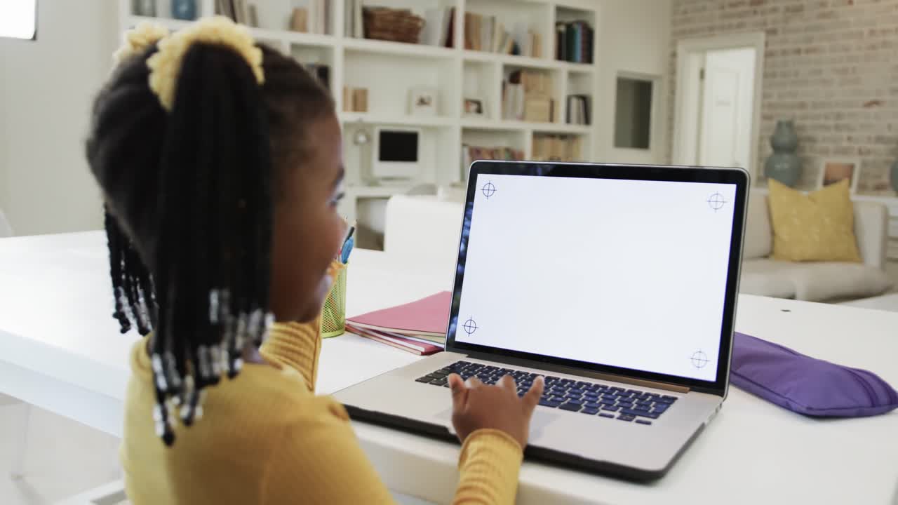 Happy african american girl in online class, using laptop with copy space on screen, slow motion