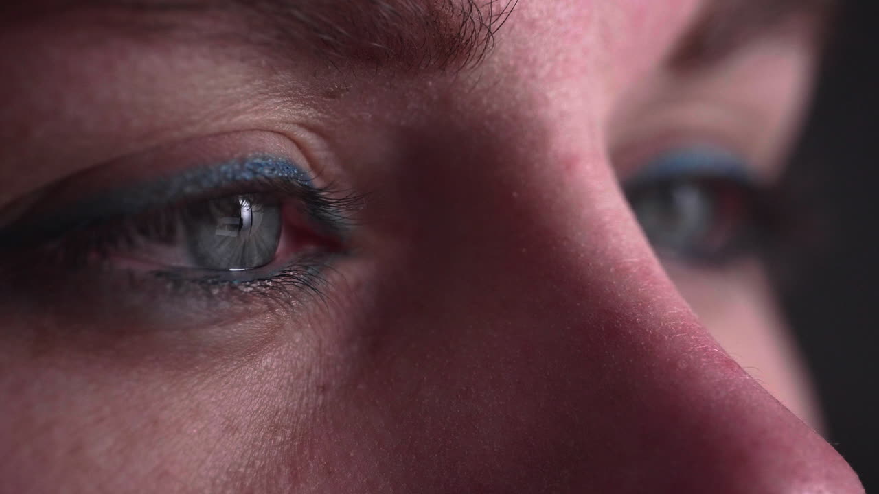 primer plano de hermosos ojos de mujer mirando el teléfono inteligente, la luz de la pantalla se refleja en los ojos - toma macro