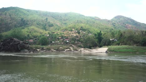 small poor laos village shot from the mekong river