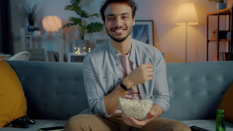 man watching movie at home with popcorn