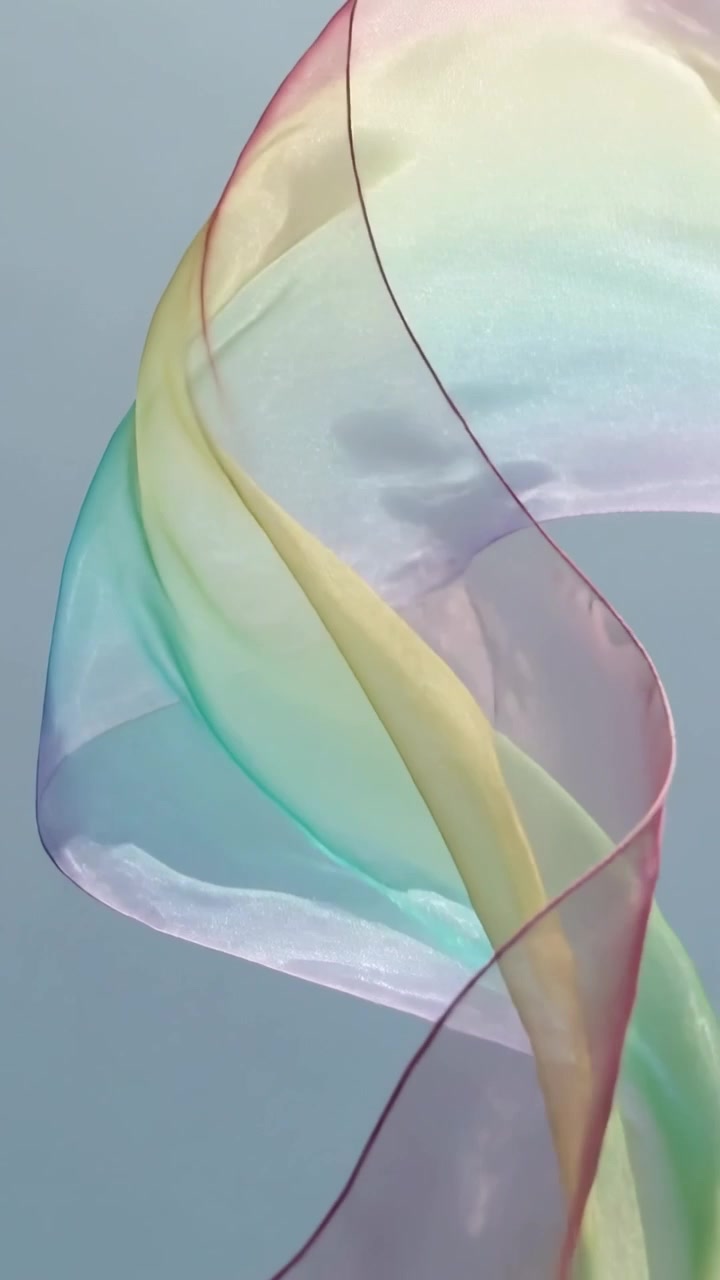 Vertical video: Lifting sheer pastel scarf, breeze looping and unfurling over pale studio backdrop