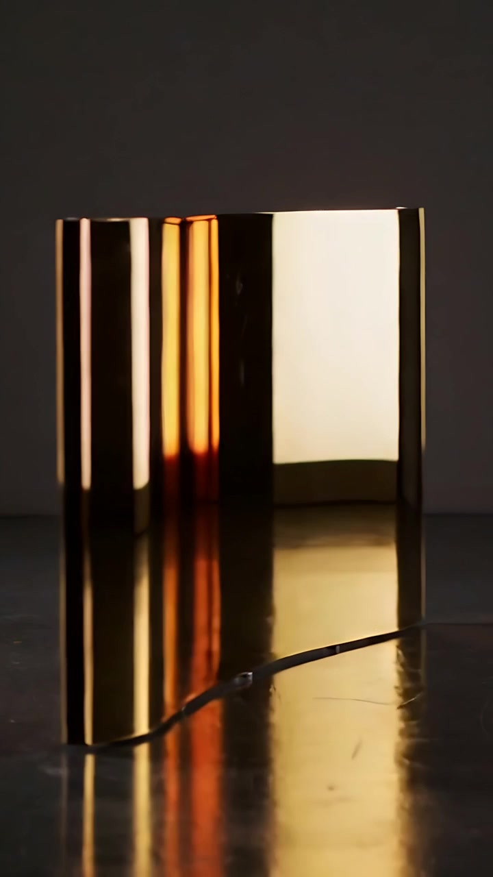 Vertical video: Pulling back cam revealing gold U-shaped object on studio tabletop, showing ridges