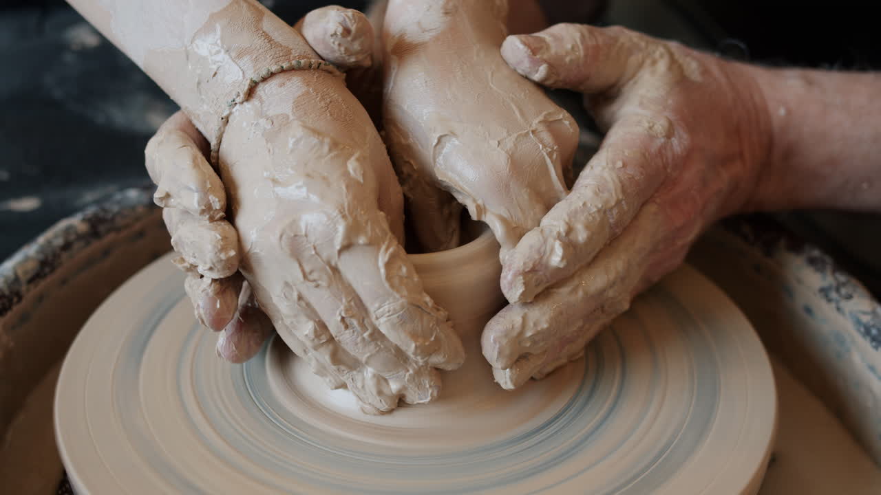 manos moldeando arcilla en la rueda de cerámica