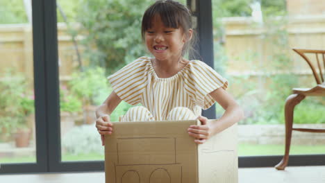 Chica-Asiática-Divirtiéndose-Jugando-En-Un-Auto-Modelado-Basura-En-El-Piso-De-La-Cocina-En-Casa